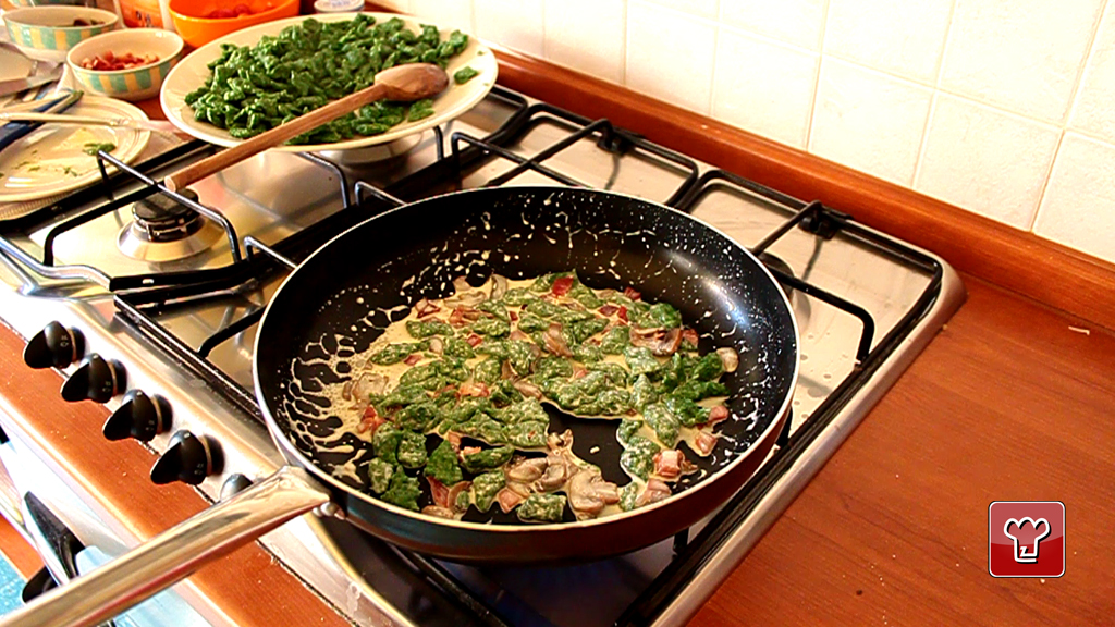 Gli spatzli saltati in padella con speck funghi e panna e quelli lessati nel piatto dietro