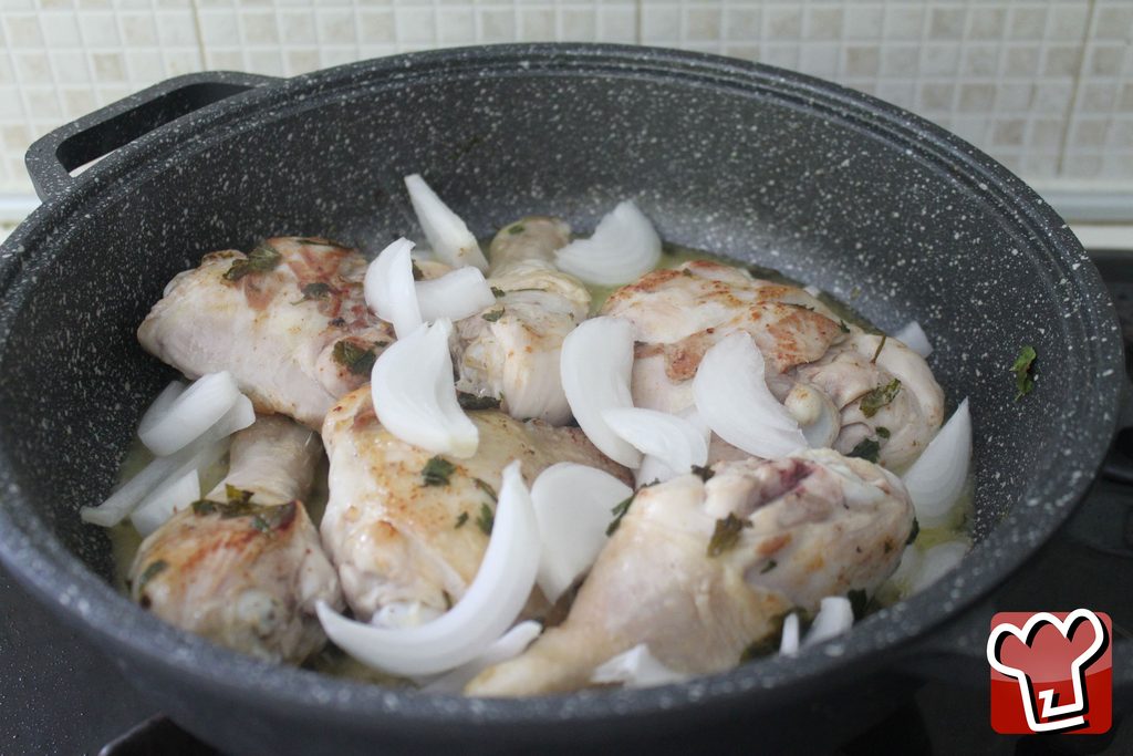 La cipolla bianca tagliata a spicchi grossi aggiunta sopra il pollo già rosolato