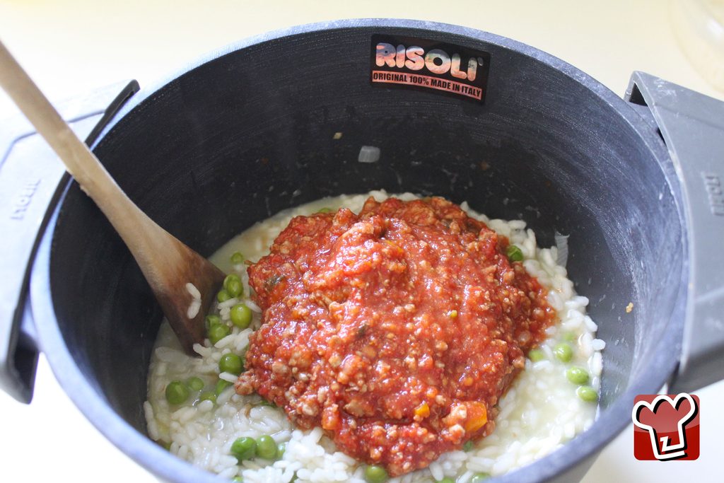 Il riso nella pentola con il ragù e i piselli: i chicchi si distinguono ancora uno a uno